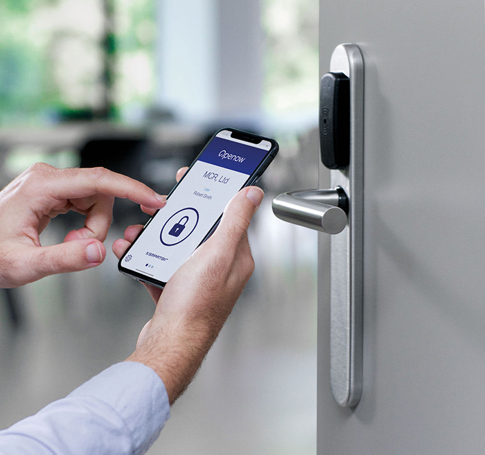 A mobile phone using the SMARTair® From Mul-T-Lock app to open a locked door